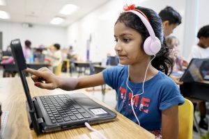 A student at a computer with a headset on