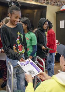 Student presents card to a resident