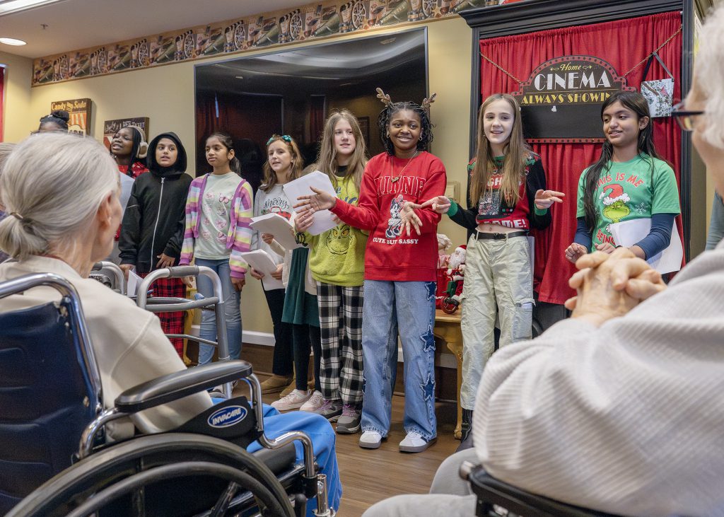Students sing in front of nursing home residents