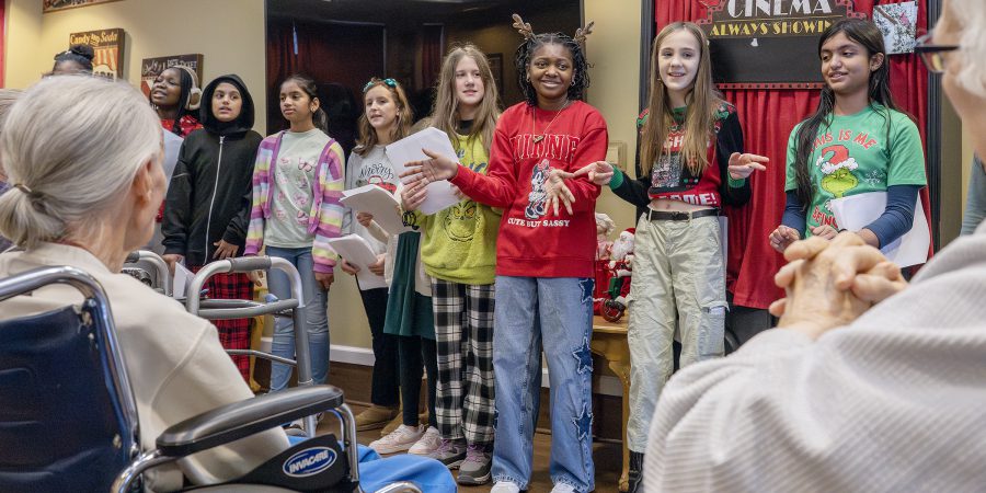 Students sing in front of nursing home residents