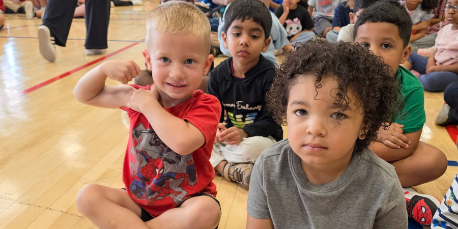 PreK student showing off their strength.