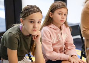 Two girls look on