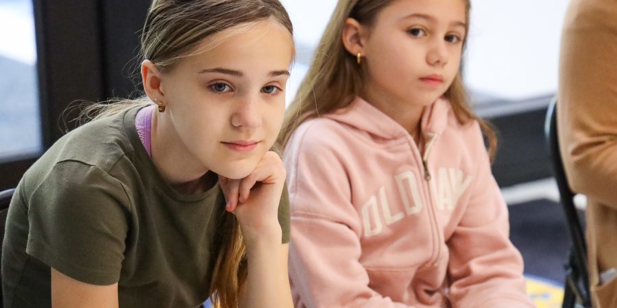 Two girls look on