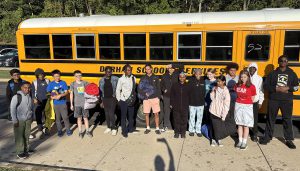 Group photo of students in front of bus