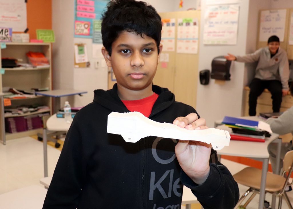 Student holds a wooden car