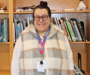 Librarian poses in front of books