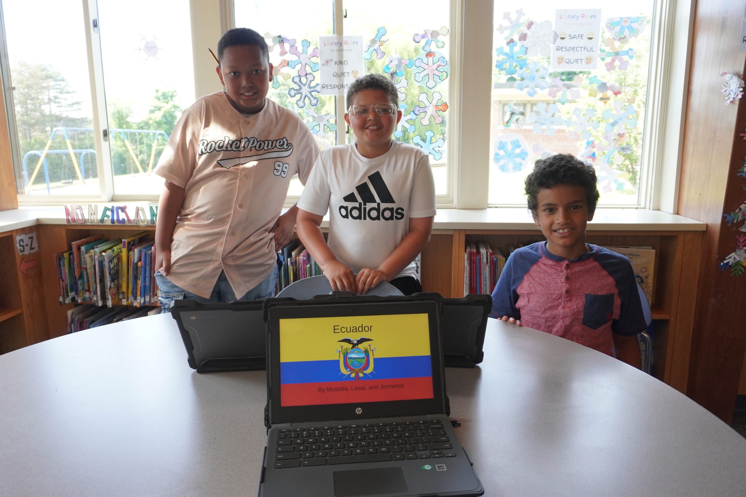 Three students smiling with computer