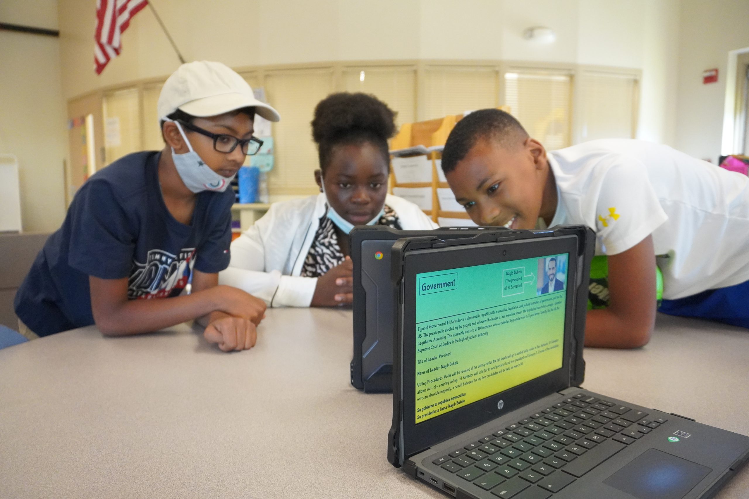 Three students reading from computer screen