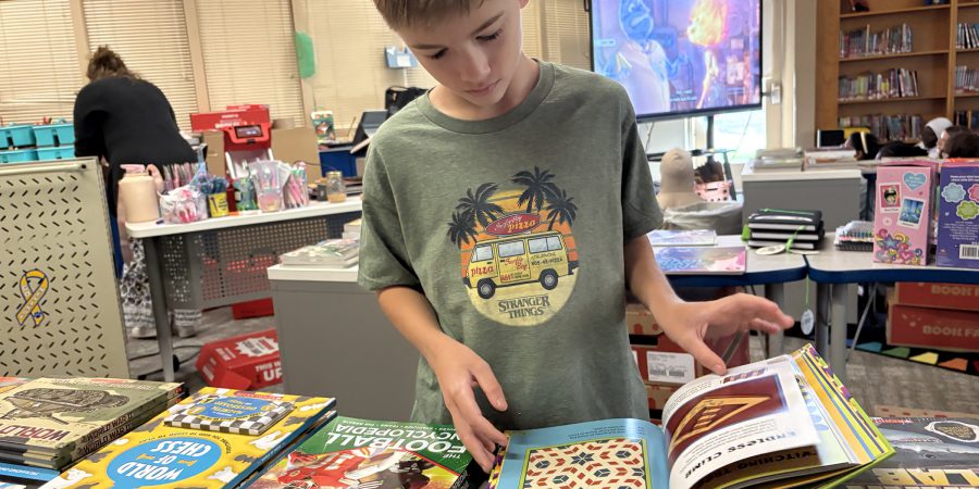 Student standing up reading a book