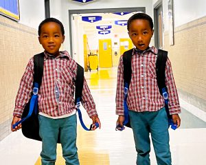 PreK twins pose in a hallway