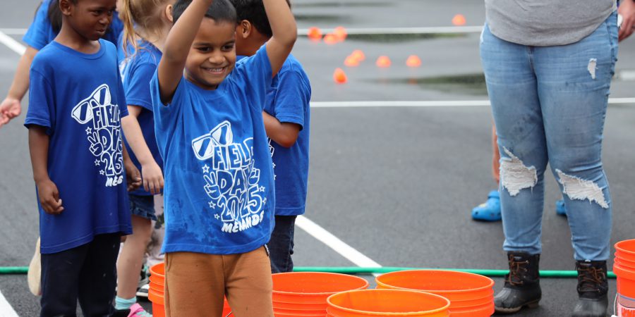 A student smiles while shooting a water balloon basket