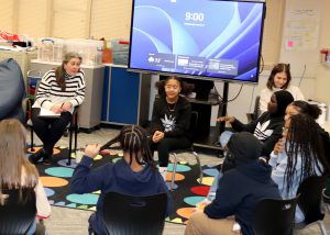 Students speak seated in a circle