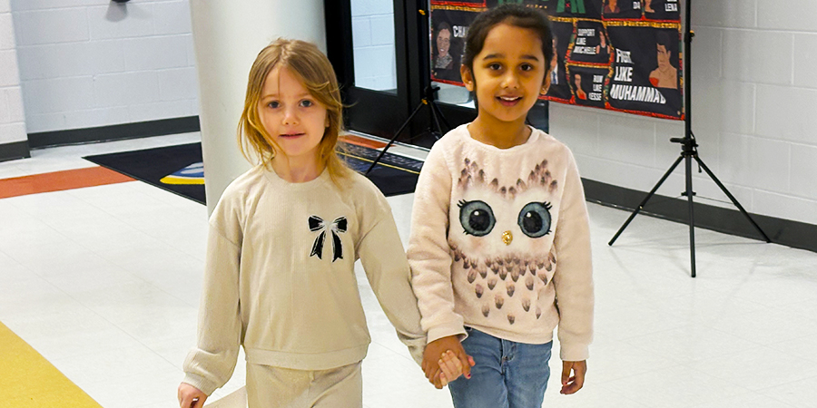 2 girls smile in the hallway