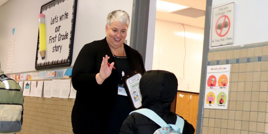 A teacher high-fives a student