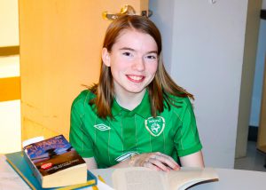 Girl smiling in front of an open book