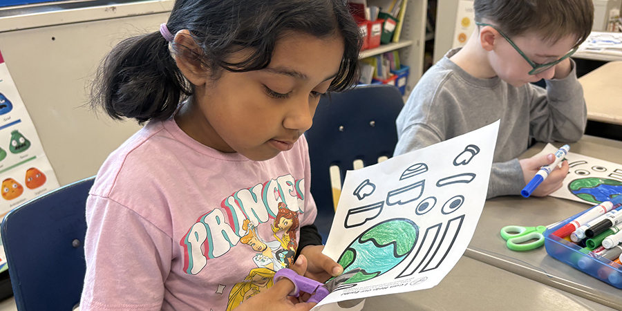 A first grade student has the world in her hands – literally.