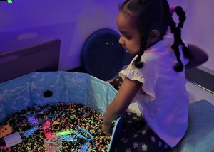 A student looks through glow in the dark materials