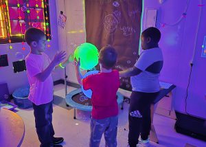 Students pass around a glow in the dark ball