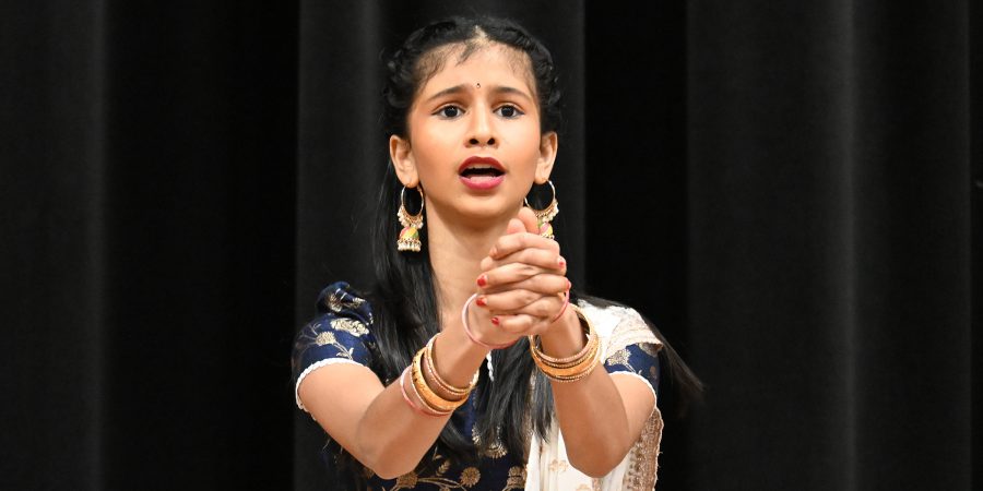 A student dances in traditional cultural costume.
