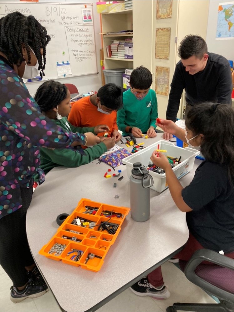 Group of students and teacher assembling legos