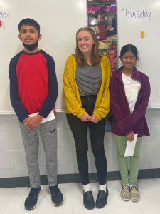 a teacher standing between two students