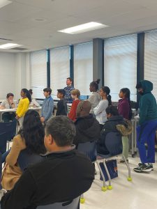 parents sitting in classroom and students lined up 