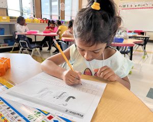 Student writing at her desk