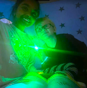 two students reading inside a tent with a glow light
