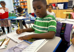Student reading and writing at desk