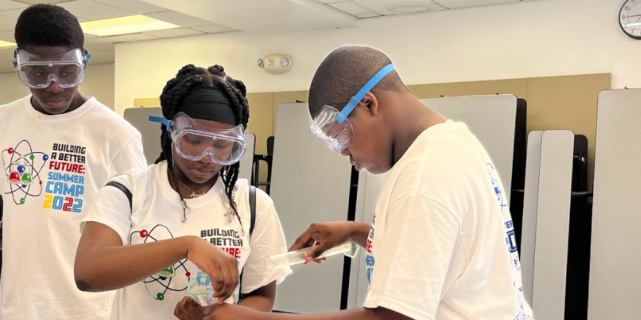 3 students wearing science goggles during experiment
