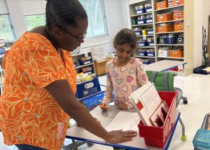 Student with teacher at a desk