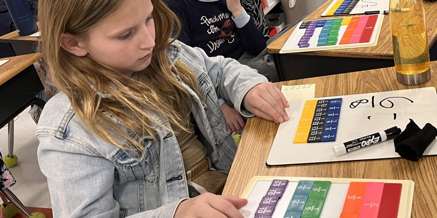 A student doing a math problem at her desk