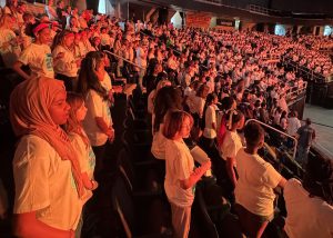 Students sing in an arena