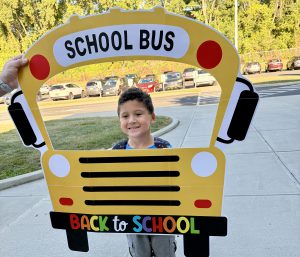 boy poses in cut-out