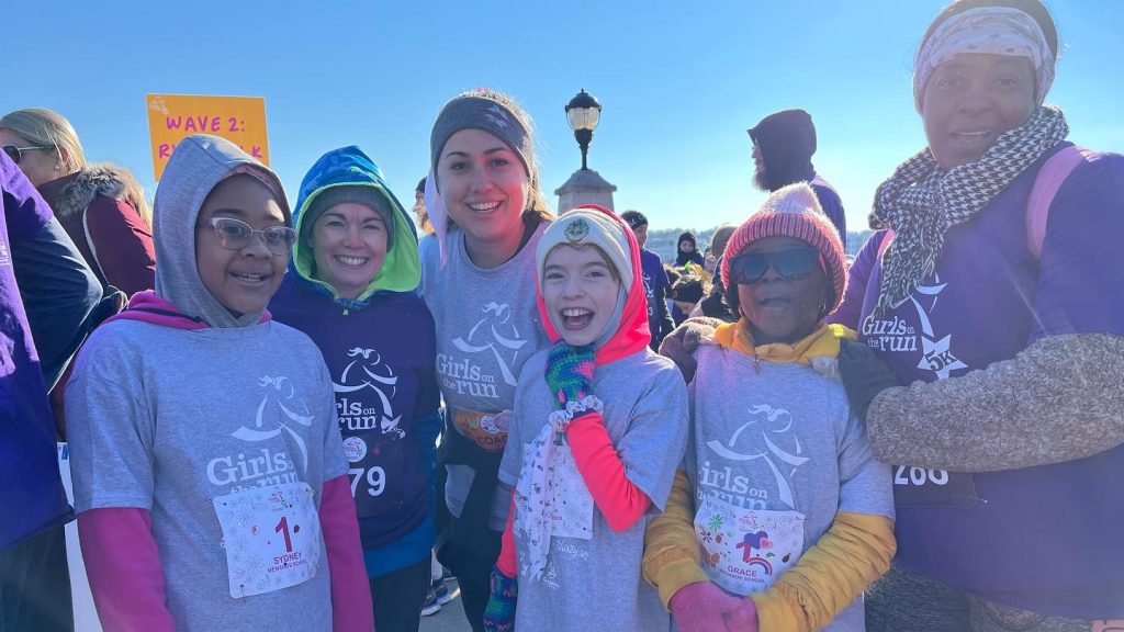 a happy group of students and adults dressed warmly and ready to run