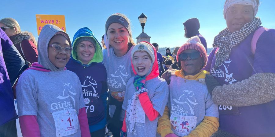 a happy group of students and adults dressed warmly and ready to run