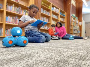 two students using tablets to program robot